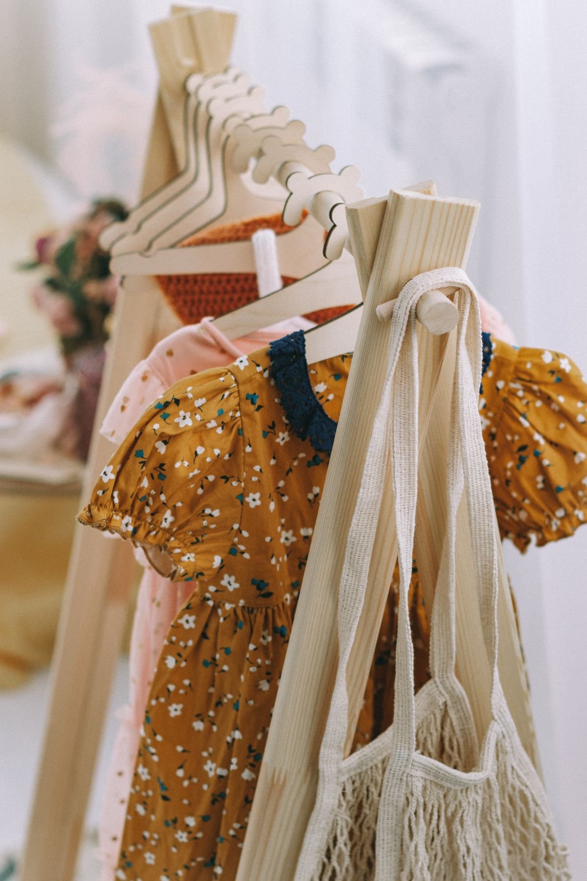 Vestidos infantis em cabides, com vestido floral amarelo na frente